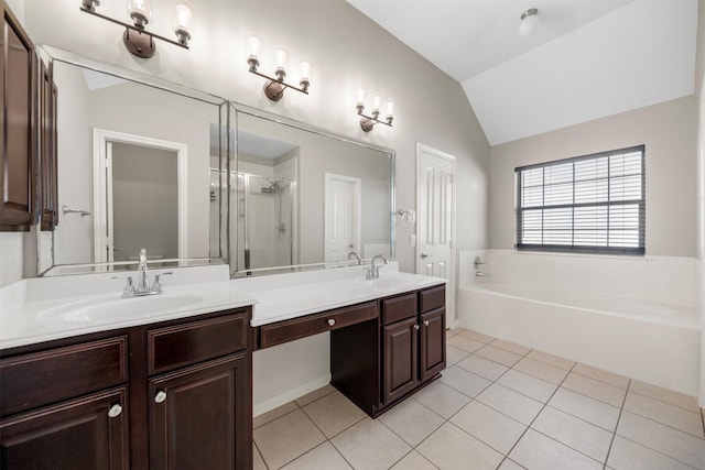 bathroom with vaulted ceiling, tile patterned floors, a stall shower, a garden tub, and double vanity