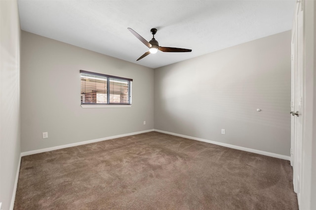 carpeted spare room with ceiling fan and baseboards