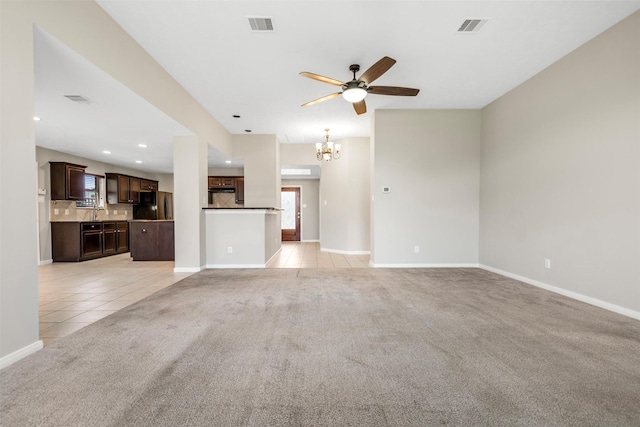 unfurnished living room with light colored carpet, ceiling fan, a chandelier, light tile patterned floors, and recessed lighting