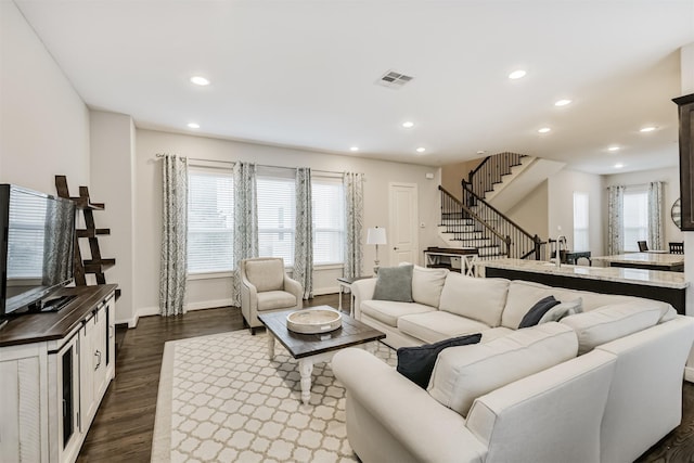 living room with recessed lighting, stairs, dark wood-type flooring, and baseboards