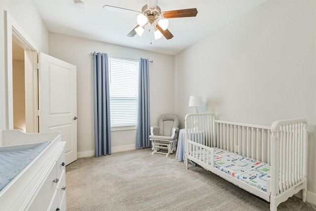 bedroom featuring light colored carpet, multiple windows, a crib, and baseboards