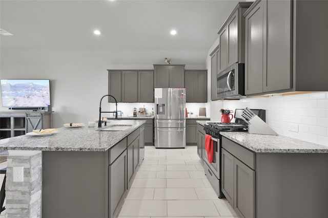 11510 Gingerland Dr, Conroe, TX 77304 - kitchen with stainless steel appliances, a sink, gray cabinets, backsplash, and recessed lighting