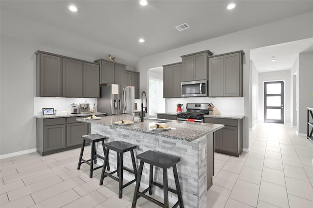 11510 Gingerland Dr, Conroe, TX 77304 - kitchen featuring appliances with stainless steel finishes, a sink, light stone counters, gray cabinets, and plenty of natural light
