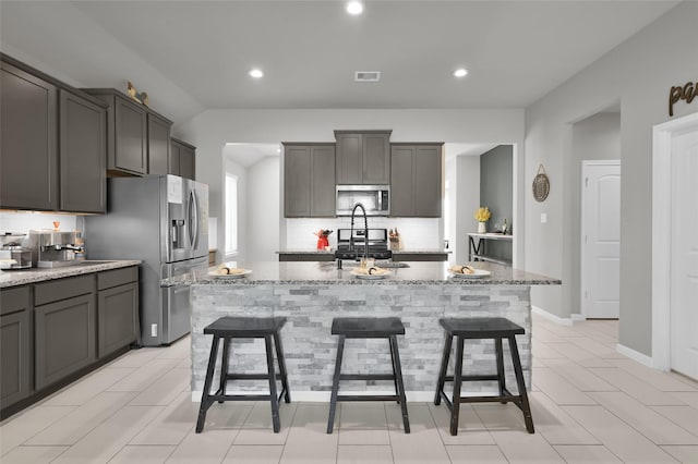 11510 Gingerland Dr, Conroe, TX 77304 - kitchen with stainless steel appliances, light stone counters, tasteful backsplash, a kitchen breakfast bar, and recessed lighting