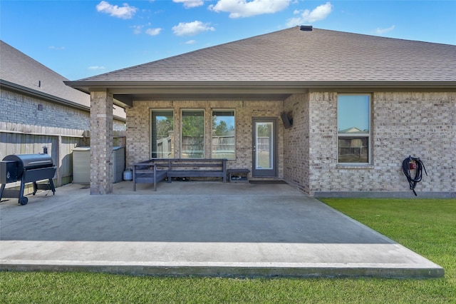 11510 Gingerland Dr, Conroe, TX 77304 - back of house featuring a patio, a shingled roof, brick siding, and fence