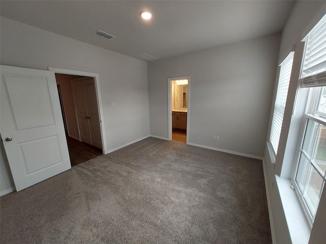 unfurnished bedroom featuring carpet floors, baseboards, and connected bathroom
