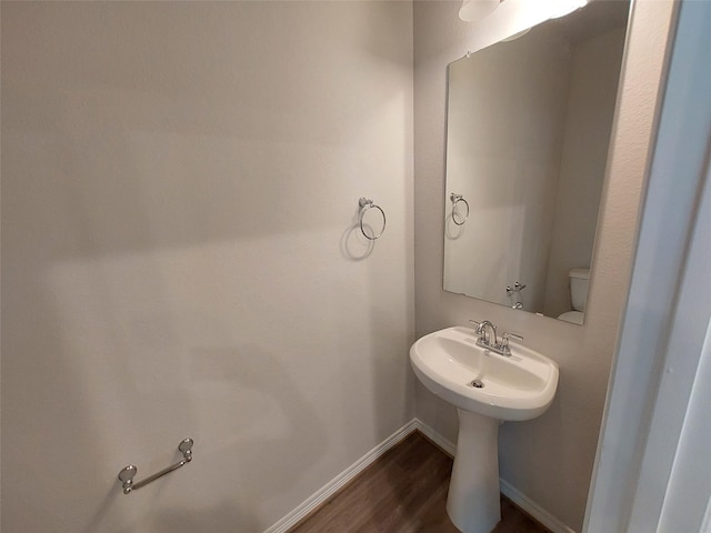 half bath with wood finished floors and baseboards