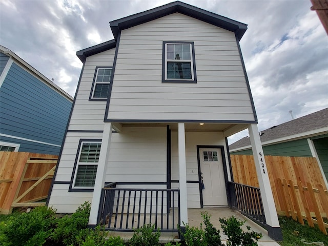 view of front facade with covered porch and fence