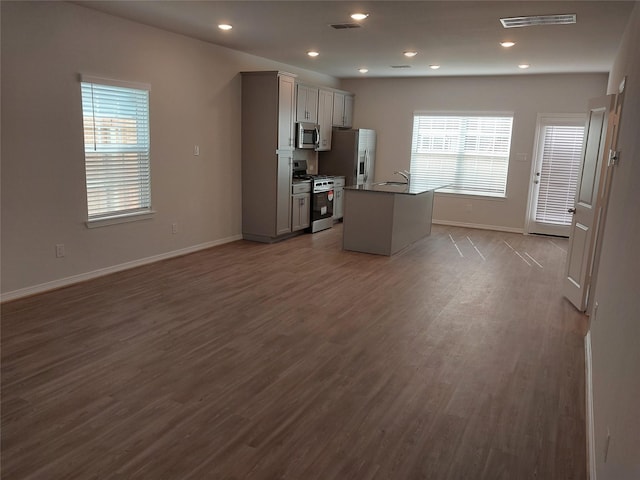 kitchen featuring appliances with stainless steel finishes, dark wood-type flooring, gray cabinets, and recessed lighting