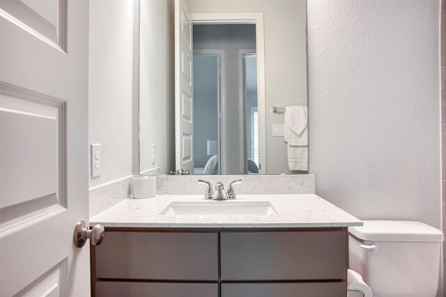 30142 Gold Finch Pl, Fulshear, TX 77441 - ensuite bathroom featuring a textured wall, vanity, and toilet