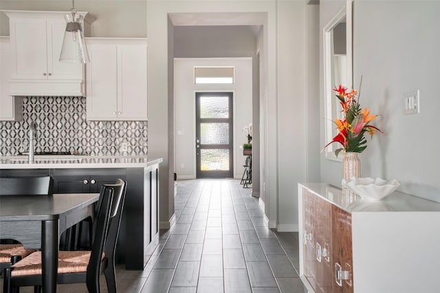 30142 Gold Finch Pl, Fulshear, TX 77441 - kitchen with decorative backsplash, light countertops, white cabinets, baseboards, and tile patterned floors