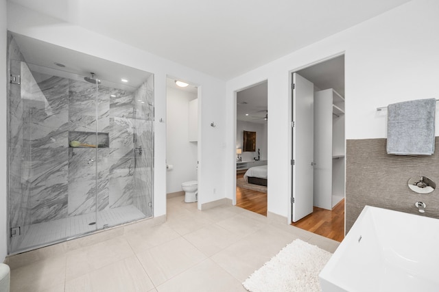 ensuite bathroom with toilet, a marble finish shower, recessed lighting, ceiling fan, and a freestanding bath