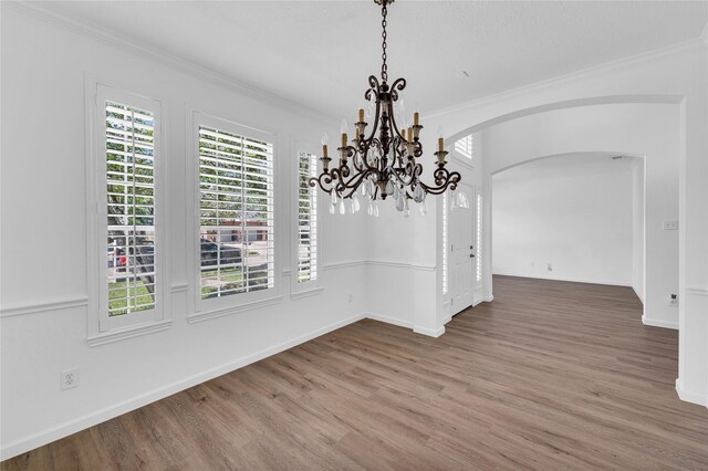 16219 Haden Crest Ct, Cypress, TX 77429 - unfurnished dining area with ornamental molding, arched walkways, wood finished floors, a chandelier, and baseboards