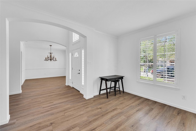 16219 Haden Crest Ct, Cypress, TX 77429 - unfurnished room featuring arched walkways, ornamental molding, a chandelier, wood finished floors, and baseboards