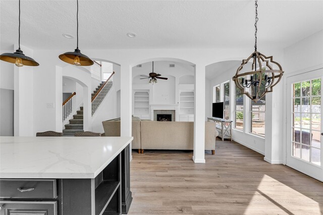16219 Haden Crest Ct, Cypress, TX 77429 - kitchen with a ceiling fan, open shelves, built in features, light wood-style flooring, and a fireplace