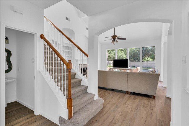 16219 Haden Crest Ct, Cypress, TX 77429 - living room featuring ceiling fan, wood finished floors, arched walkways, stairway, and baseboards