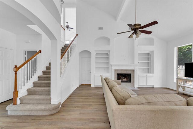 16219 Haden Crest Ct, Cypress, TX 77429 - living room featuring ceiling fan, wood finished floors, built in features, stairway, and high vaulted ceiling