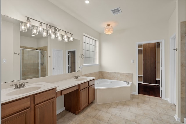 full bath featuring a stall shower, a chandelier, double vanity, a bath, and a closet