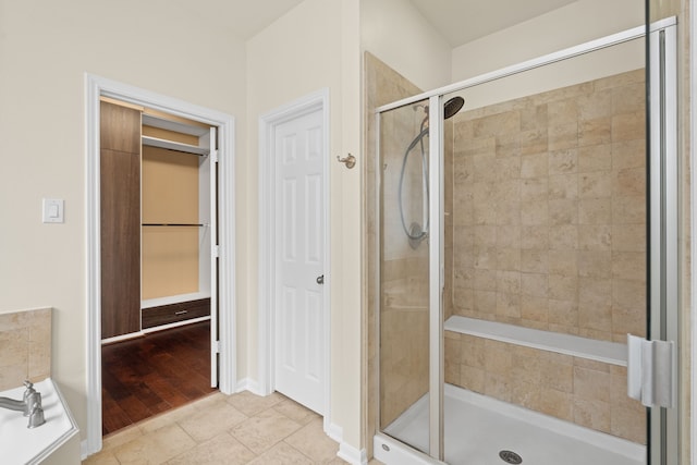 bathroom with a shower stall, tile patterned floors, and a bath