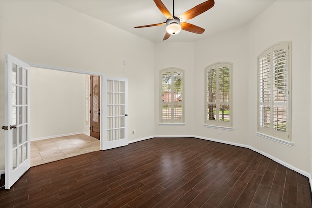 unfurnished room with french doors, a ceiling fan, wood finished floors, and baseboards