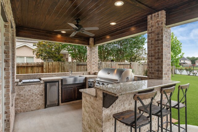 view of patio / terrace featuring exterior kitchen, area for grilling, and a ceiling fan