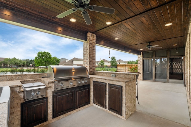 view of patio featuring a grill, ceiling fan, exterior kitchen, and fence