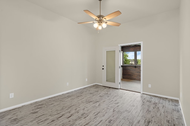 empty room with wood finished floors, baseboards, and a ceiling fan