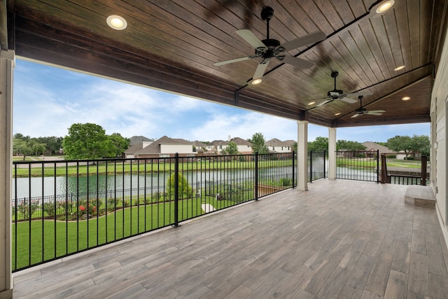 wooden deck with a water view, ceiling fan, a yard, and a residential view
