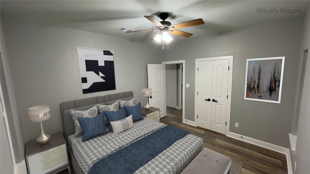bedroom featuring wood finished floors, baseboards, a ceiling fan, and a closet
