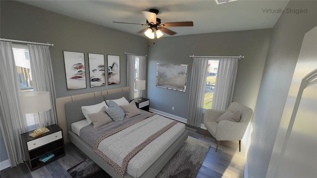 bedroom featuring wood finished floors, baseboards, and ceiling fan