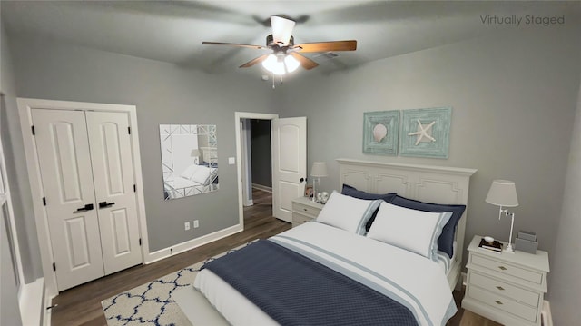 bedroom featuring dark wood-style flooring, baseboards, a ceiling fan, and a closet