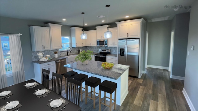 kitchen with appliances with stainless steel finishes, a sink, tasteful backsplash, dark wood-type flooring, and recessed lighting