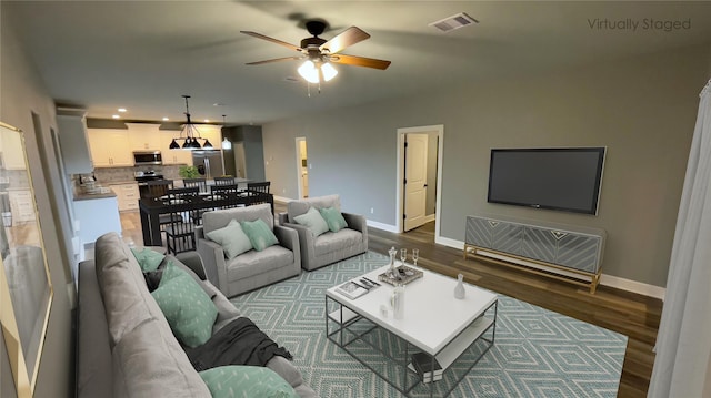 living area with baseboards, wood finished floors, a ceiling fan, and recessed lighting
