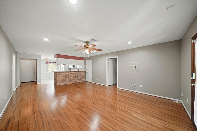 21410 Glenbranch Dr, Spring, TX 77388 - unfurnished living room with baseboards, ceiling fan, light wood finished floors, recessed lighting, and a textured ceiling