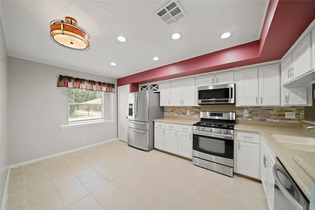21410 Glenbranch Dr, Spring, TX 77388 - kitchen featuring stainless steel appliances, a sink, decorative backsplash, light countertops, and white cabinets