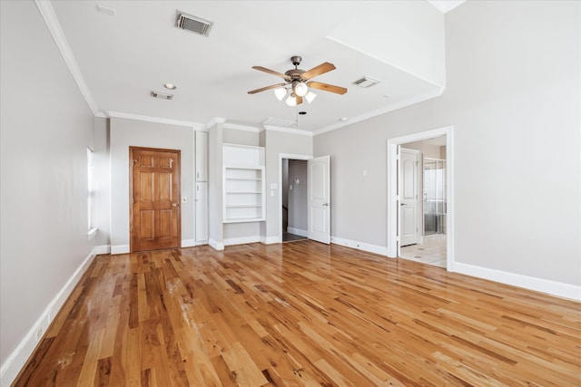unfurnished bedroom featuring crown molding, light wood-type flooring, baseboards, ensuite bathroom, and a ceiling fan