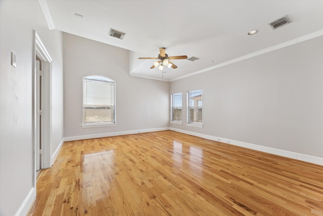 spare room with light wood finished floors, ceiling fan, baseboards, and crown molding