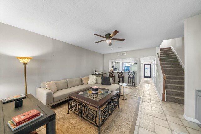 1924 Clipper Ct, Willis, TX 77318 - living room featuring stairway, a ceiling fan, and a textured ceiling