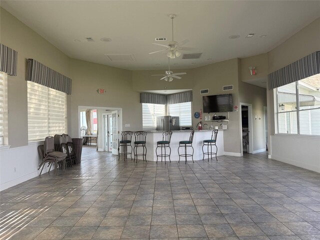 1924 Clipper Ct, Willis, TX 77318 - kitchen with freestanding refrigerator, a ceiling fan, a towering ceiling, a breakfast bar area, and plenty of natural light