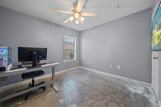 office area with concrete flooring, baseboards, and a ceiling fan