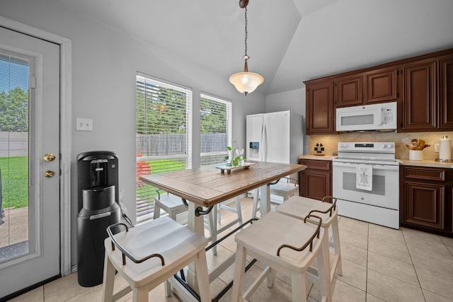 kitchen with white appliances, vaulted ceiling, backsplash, light countertops, and pendant lighting