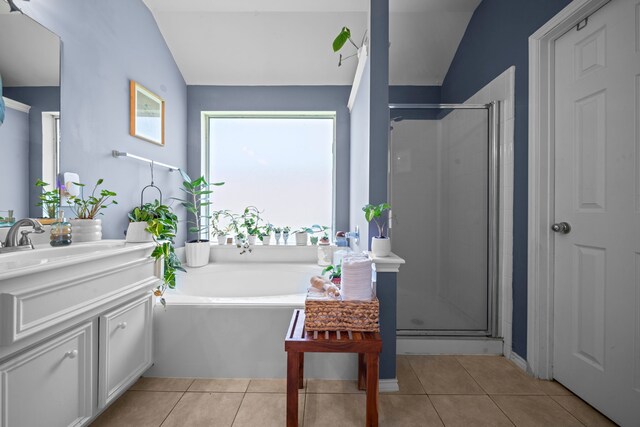 full bath featuring lofted ceiling, a shower stall, vanity, a garden tub, and tile patterned floors