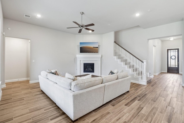 531 Campbell Dr, League City, TX 77573 - living area featuring light wood-type flooring, a glass covered fireplace, ceiling fan, baseboards, and recessed lighting