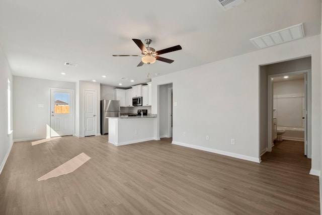 425 Tejas Trl, Waller, TX 77484 - unfurnished living room with a ceiling fan, baseboards, light wood finished floors, and recessed lighting