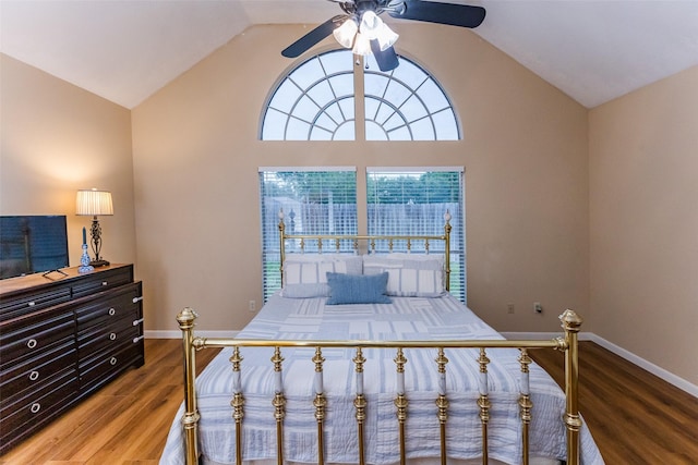 bedroom featuring wood finished floors, vaulted ceiling, baseboards, and ceiling fan