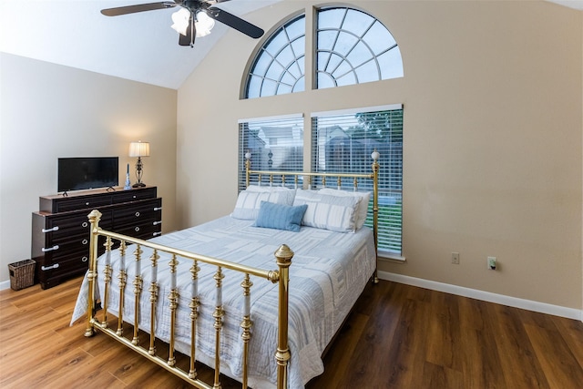 bedroom featuring high vaulted ceiling, baseboards, wood finished floors, and a ceiling fan
