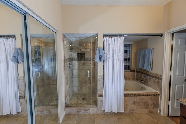 bathroom featuring a stall shower, a bath, tile patterned floors, and vanity