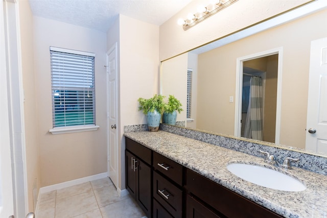 full bathroom featuring vanity, tile patterned flooring, baseboards, and a shower with shower curtain