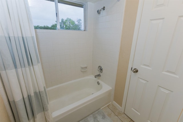 full bath featuring shower / bath combo with shower curtain, tile patterned flooring, and baseboards