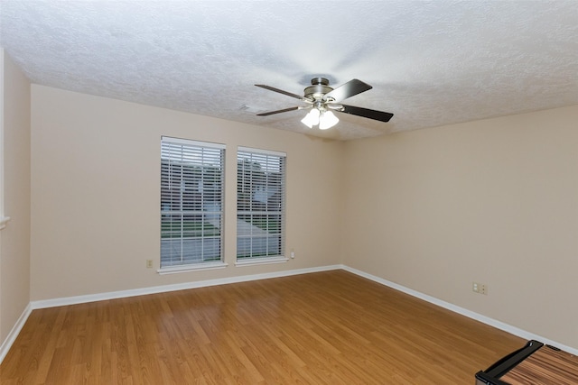 unfurnished room featuring light wood-type flooring, a ceiling fan, baseboards, and a textured ceiling